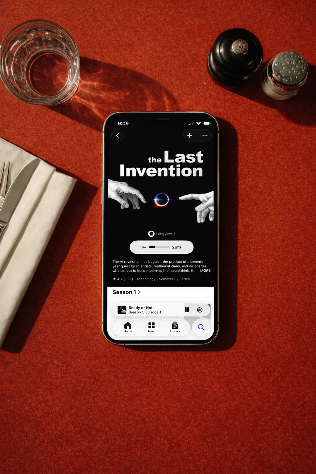 A listener playing The Last Invention on a phone resting on a diner table